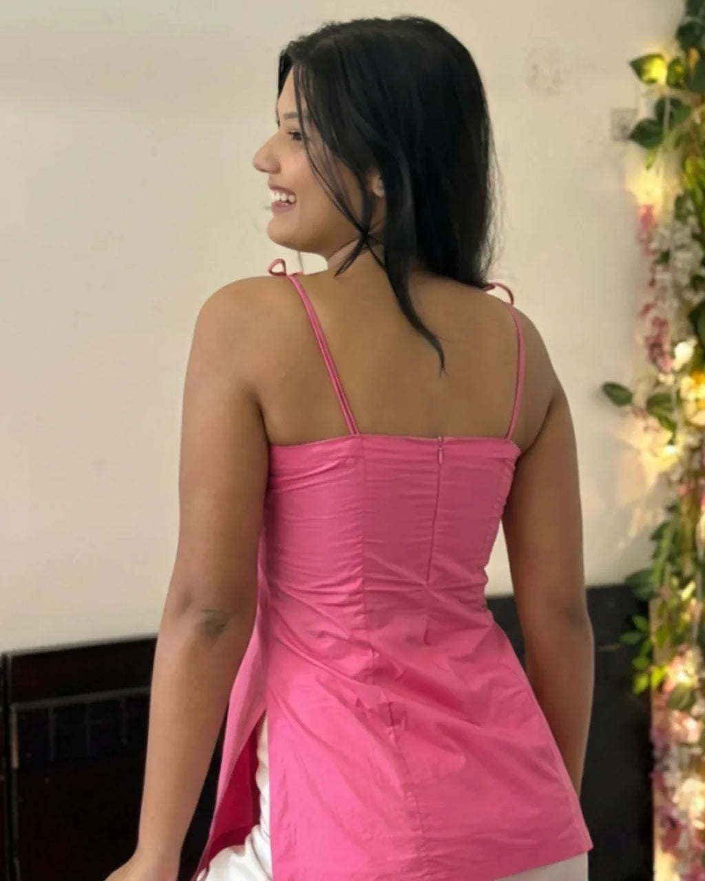 Pink sleeveless dress with ruched back and thin straps, elegant contemporary women's fashion